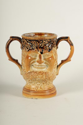 Lot 56 - AN UNUSUAL 19TH CENTURY DOULTON TYPE SALT GLAZED STONEWARE DOUBLE SIDED TWO HANDLED MASK HEAD LOVING CUP