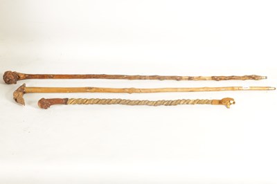 Lot 484 - TWO MASK HEAD CARVED WOOD WALKING STICKS AND A RIDING CROP