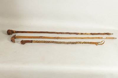 Lot 484 - TWO MASK HEAD CARVED WOOD WALKING STICKS AND A RIDING CROP