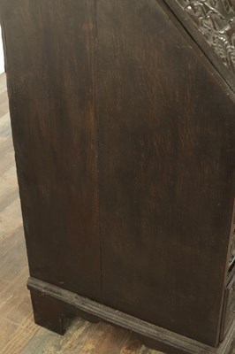 Lot 835 - A GEORGE III CARVED OAK BUREAU