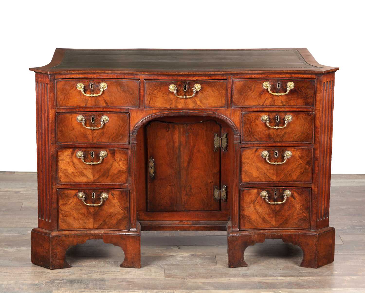 Lot 1484 - A GEORGE III FLAMED MAHOGANY SERPENTINE FRONTED KNEEHOLE DESK
