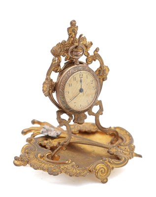 Lot 324 - AN ART NOUVEAU BRASS WATCH HOLDER AND POCKET WATCH