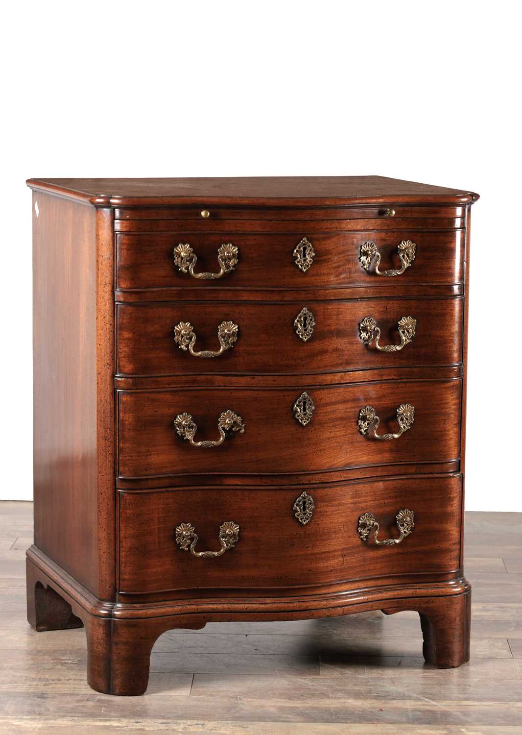 Lot 1515 - AN UNUSUAL GEORGE III MAHOGANY SERPENTINE CHEST OF DRAWERS WITH BRUSHING SLIDE